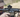 A shooter aiming down the sights of an advanced rifle equipped with a red dot scope 